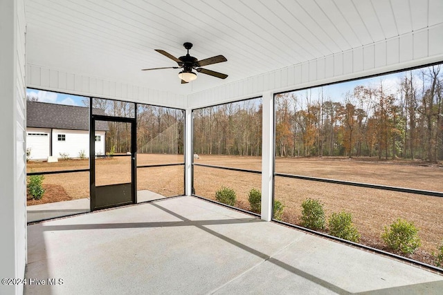 unfurnished sunroom featuring ceiling fan and a healthy amount of sunlight