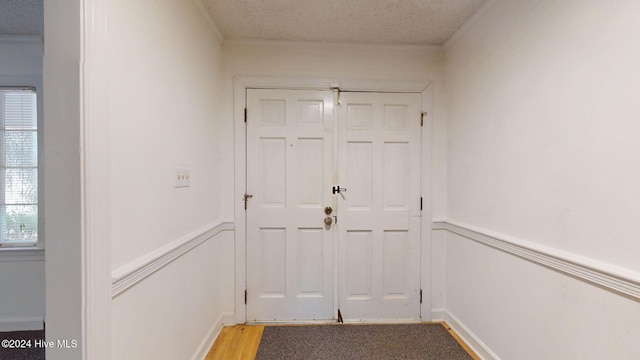 doorway featuring a textured ceiling and light hardwood / wood-style flooring