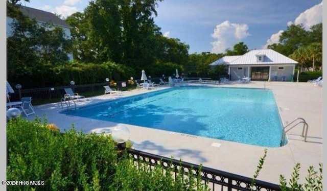 view of swimming pool with a patio area and an outbuilding