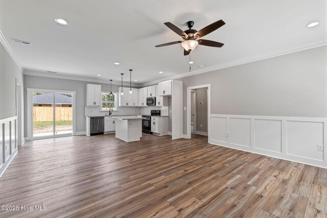 2013 E Hawthorne St, Goldsboro, NC 27530 - unfurnished living room with ornamental molding, recessed lighting, a ceiling fan, wood finished floors, and a wainscoted wall