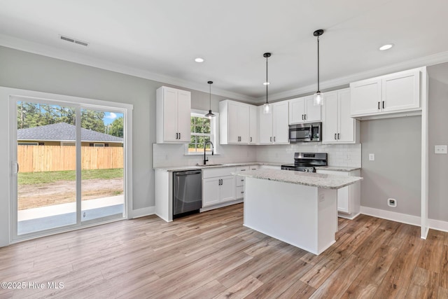 2013 E Hawthorne St, Goldsboro, NC 27530 - kitchen with stainless steel appliances, a sink, backsplash, white cabinetry, and crown molding