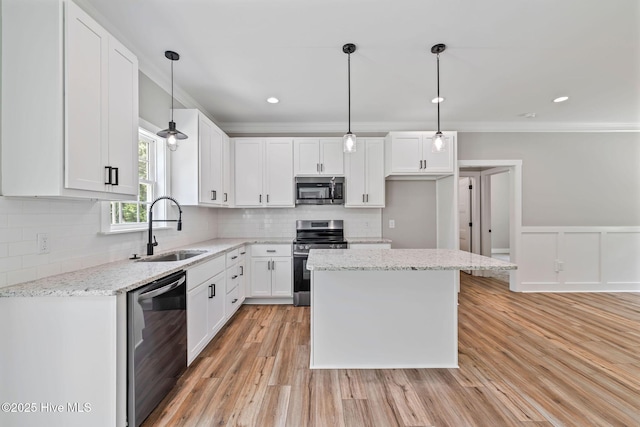 2013 E Hawthorne St, Goldsboro, NC 27530 - kitchen with appliances with stainless steel finishes, a sink, ornamental molding, white cabinets, and a wainscoted wall