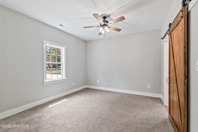 2013 E Hawthorne St, Goldsboro, NC 27530 - unfurnished bedroom featuring a barn door, carpet, baseboards, and a ceiling fan