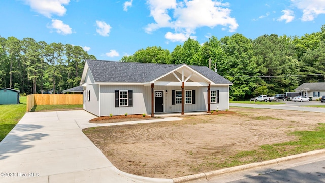 2013 E Hawthorne St, Goldsboro, NC 27530 - modern inspired farmhouse with concrete driveway, covered porch, roof with shingles, and an outbuilding