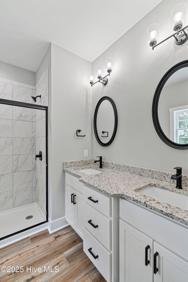 2013 E Hawthorne St, Goldsboro, NC 27530 - bathroom with double vanity, a shower stall, wood finished floors, and baseboards