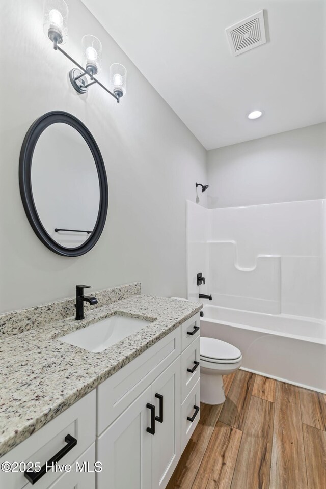 2013 E Hawthorne St, Goldsboro, NC 27530 - bathroom with vanity, toilet, wood finished floors, tub / shower combination, and recessed lighting