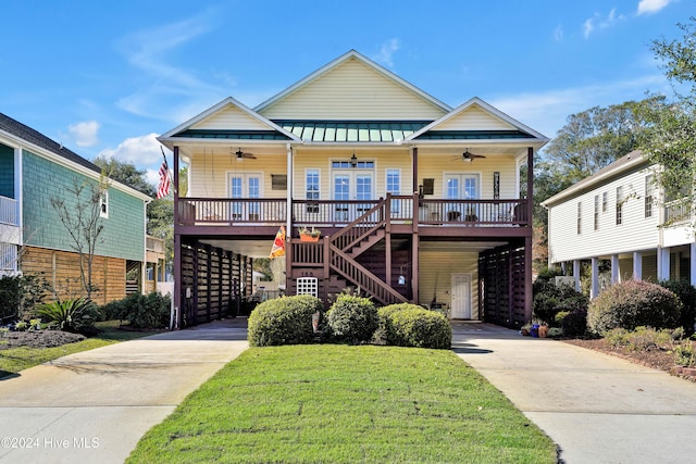 view of front facade featuring a front yard, french doors, a carport, a porch, and ceiling fan