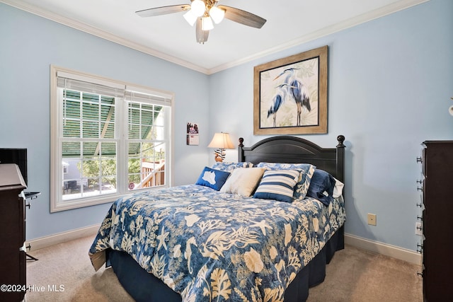 carpeted bedroom with ceiling fan and ornamental molding