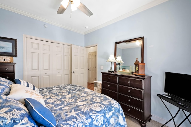 carpeted bedroom with a closet, ceiling fan, and crown molding