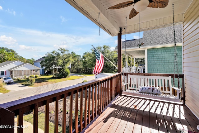 wooden deck featuring covered porch and ceiling fan