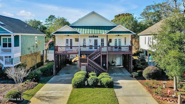 view of front facade with ceiling fan, french doors, a porch, and a carport