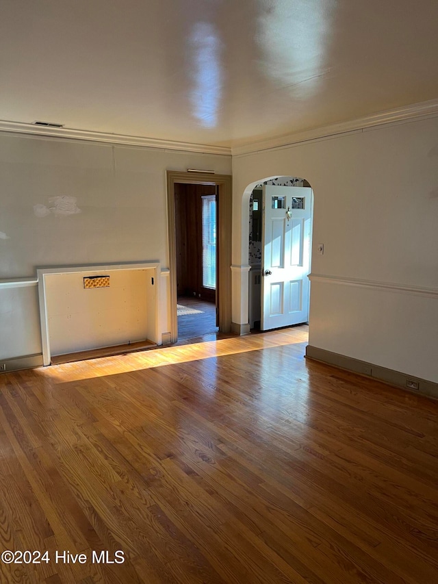 unfurnished room featuring ornamental molding and hardwood / wood-style floors