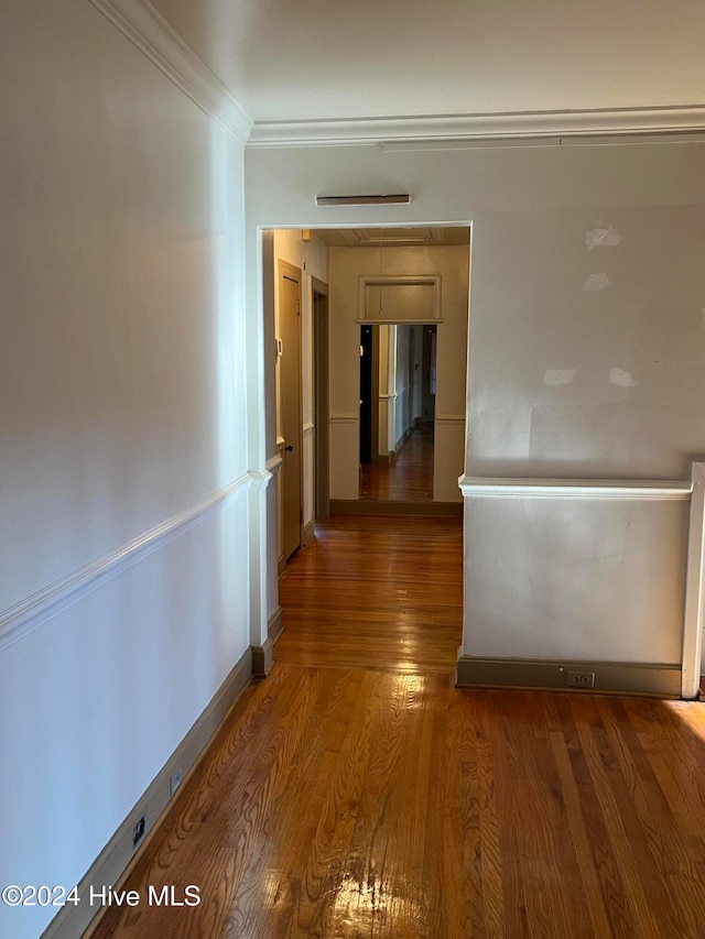 hallway with ornamental molding and dark hardwood / wood-style floors