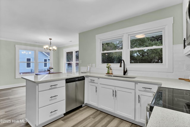 kitchen with sink, appliances with stainless steel finishes, white cabinets, decorative light fixtures, and kitchen peninsula