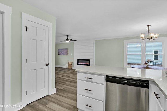 kitchen featuring a fireplace, white cabinetry, hanging light fixtures, stainless steel dishwasher, and light hardwood / wood-style flooring