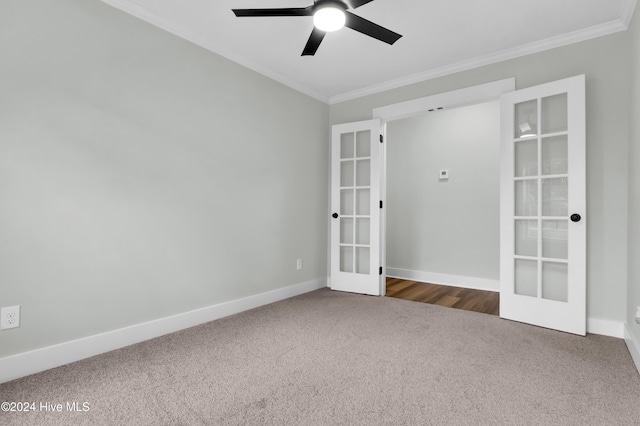 spare room featuring crown molding, french doors, ceiling fan, and dark colored carpet