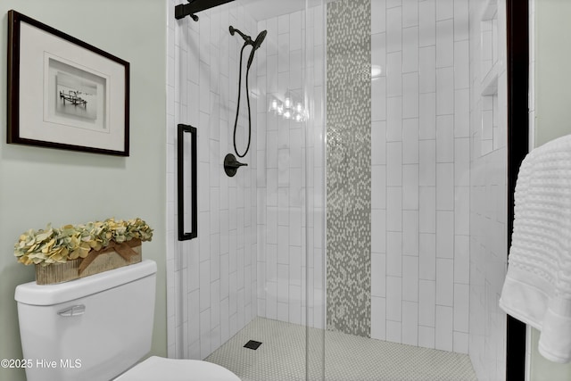 bathroom with a shower with shower door and toilet