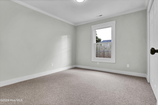 unfurnished room with ornamental molding and carpet