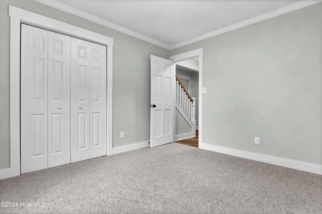 unfurnished bedroom with ornamental molding, carpet flooring, and a closet