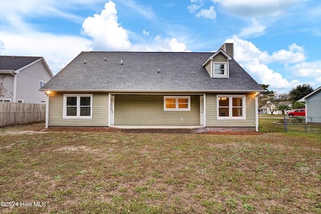 rear view of property featuring a yard and a patio area