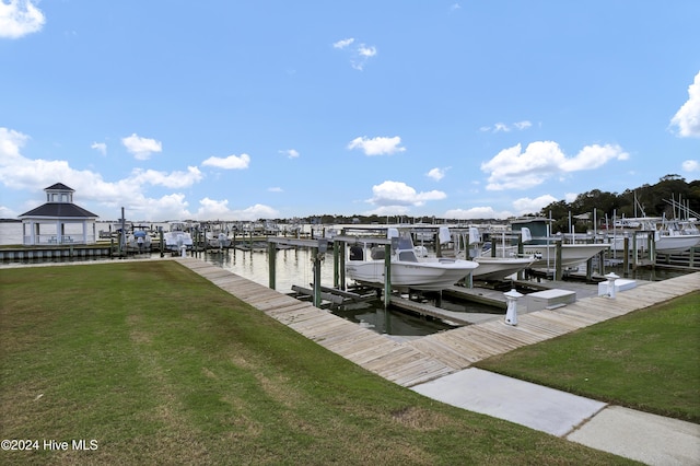 view of dock featuring a lawn and a water view