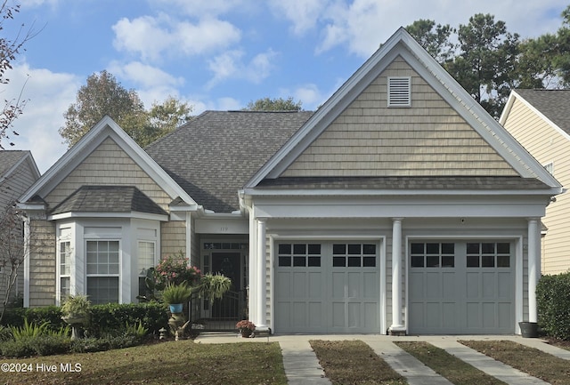 view of front facade with an attached garage, concrete driveway, and roof with shingles