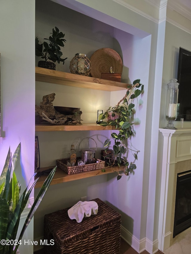 bar featuring a fireplace, crown molding, and baseboards