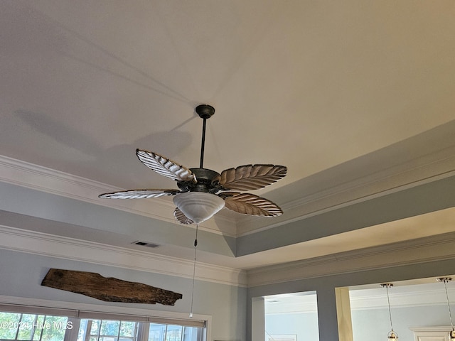 interior details with visible vents, a raised ceiling, crown molding, and ceiling fan