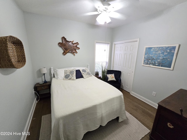 bedroom with dark wood finished floors, ceiling fan, a closet, and baseboards