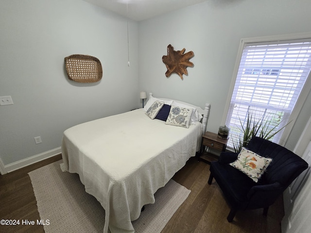 bedroom featuring dark wood finished floors and baseboards