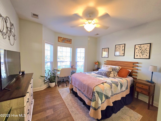 bedroom featuring dark wood-type flooring, baseboards, visible vents, and ceiling fan