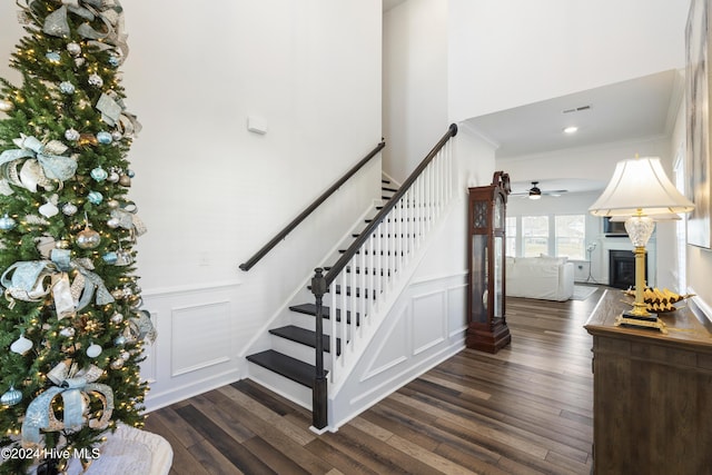 stairway with hardwood / wood-style floors, ceiling fan, and ornamental molding