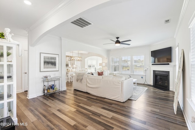 living room featuring crown molding, ceiling fan with notable chandelier, and dark hardwood / wood-style flooring