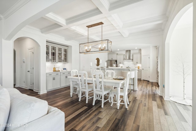 dining space with beamed ceiling, ornamental molding, coffered ceiling, and dark wood-style flooring