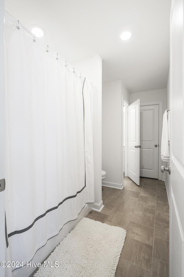 bedroom with visible vents, light carpet, a sink, ensuite bath, and baseboards