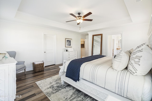 bedroom with crown molding, dark hardwood / wood-style floors, ceiling fan, and a raised ceiling