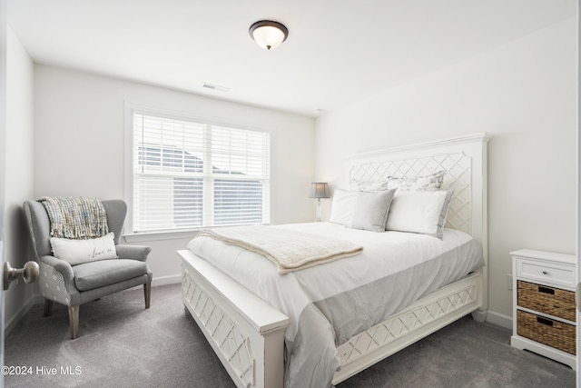 bedroom featuring visible vents, dark carpet, and baseboards