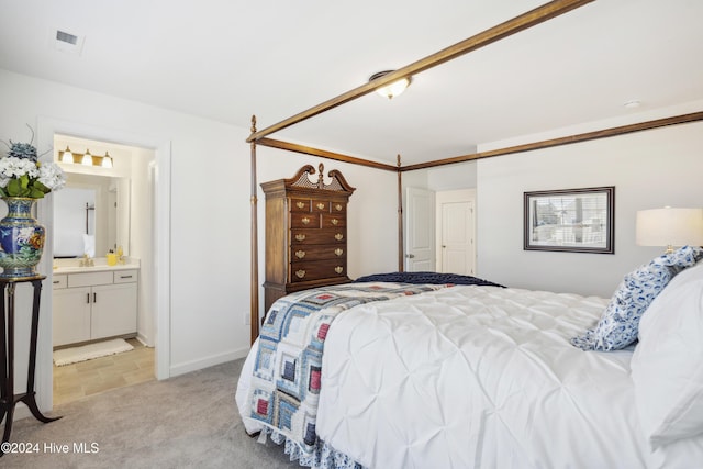 carpeted bedroom featuring sink and ensuite bath