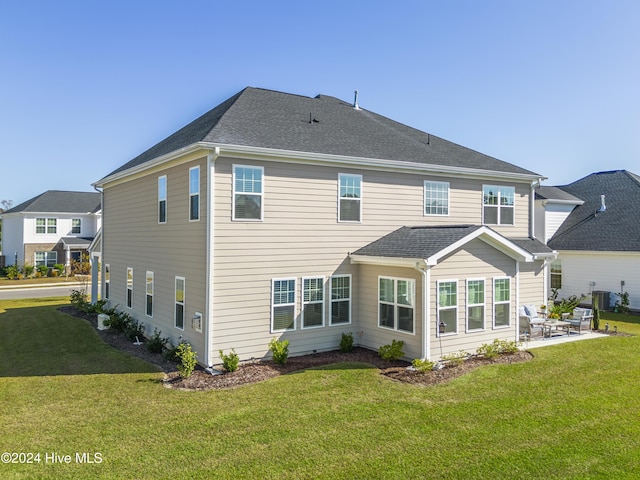 rear view of property featuring central air condition unit, a patio, and a lawn