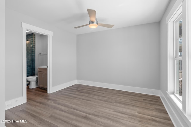 unfurnished bedroom with ensuite bath, light hardwood / wood-style floors, and ceiling fan