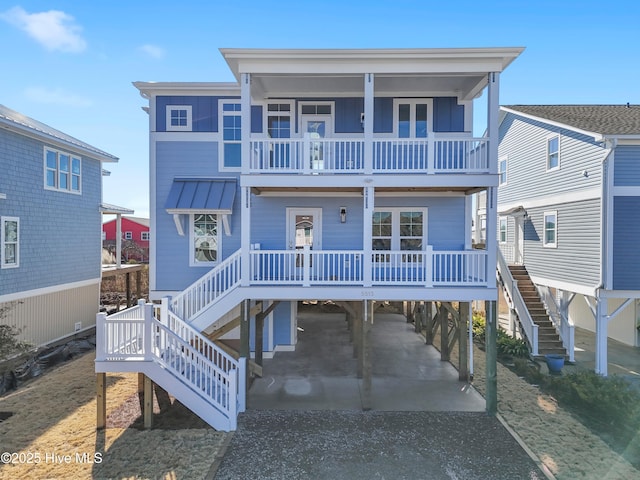 raised beach house with a porch, a balcony, and a carport