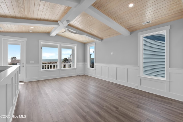 interior space with lofted ceiling with beams, ceiling fan, hardwood / wood-style floors, and wooden ceiling