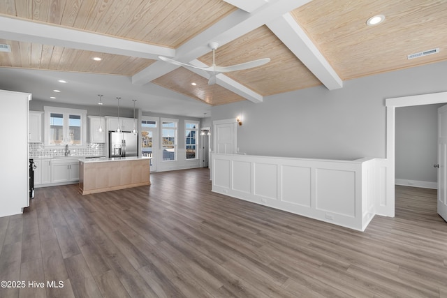 unfurnished living room featuring sink, ceiling fan, vaulted ceiling with beams, dark hardwood / wood-style flooring, and wooden ceiling