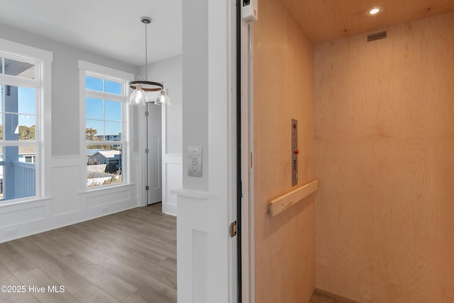 interior space featuring elevator and light hardwood / wood-style flooring