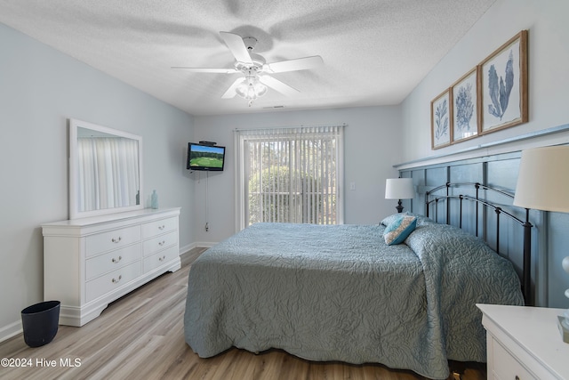 bedroom featuring ceiling fan, a textured ceiling, and light wood-type flooring