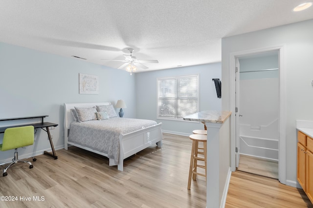 bedroom with ceiling fan, a textured ceiling, and light wood-type flooring