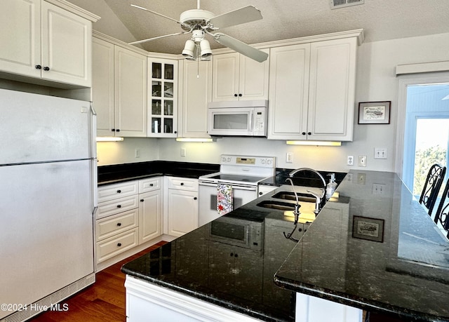 kitchen with white cabinetry, white appliances, and kitchen peninsula