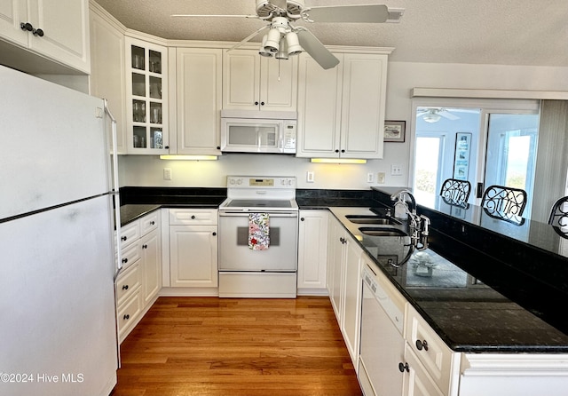 kitchen with white cabinets, white appliances, light hardwood / wood-style floors, and sink