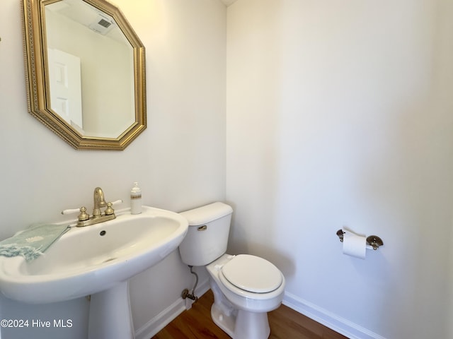 bathroom with hardwood / wood-style floors, toilet, and sink