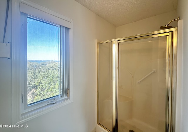 bathroom featuring a textured ceiling and walk in shower